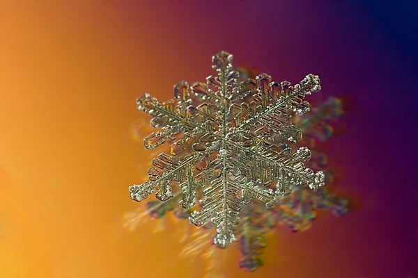 Snowflake on yellow and red — Stock Photo, Image