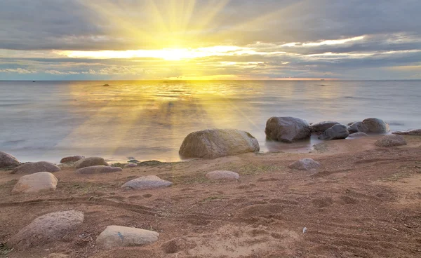 Sol acima de pedras na praia — Fotografia de Stock