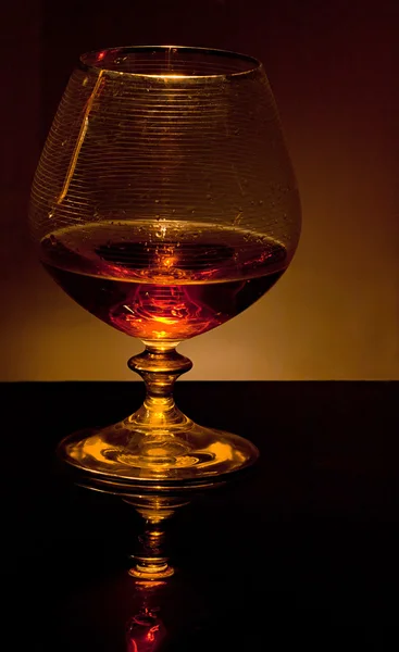 Glas med konjak i mörkret — Stockfoto