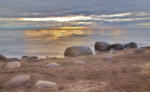 Stenen op zonsondergang strand — Stockfoto