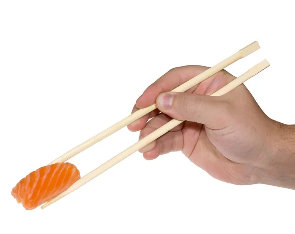 Main humaine avec baguettes et sushis — Photo