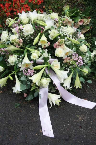 White sympathy flowers near a grave — Stock Photo, Image