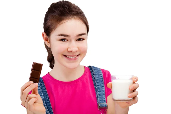 Menina comer bar de chocolate e beber leite — Fotografia de Stock
