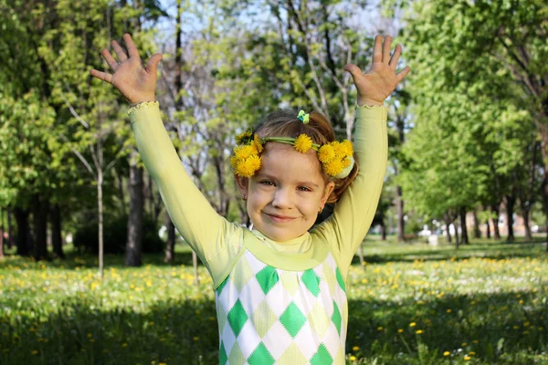 Criança feliz no parque com as mãos para cima e coroa na cabeça — Fotografia de Stock