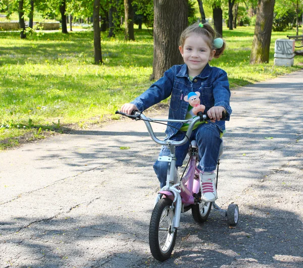 Lapsi ratsastus polkupyörän puistossa — kuvapankkivalokuva