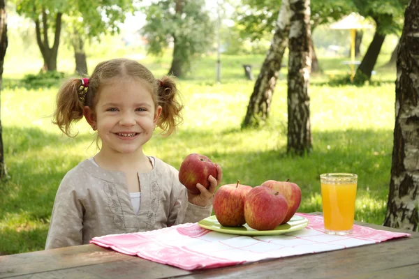 苹果和果汁在公园的小女孩 — 图库照片