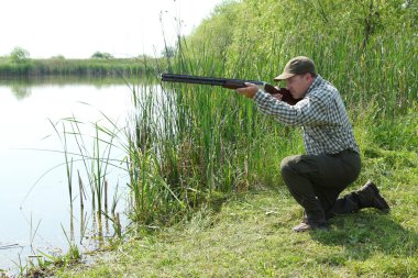 Hunter aiming and ready for shot wild duck hunting clipart