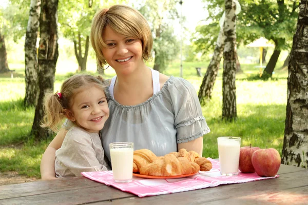 Gelukkig moeder en dochter met gezond ontbijt — Stockfoto