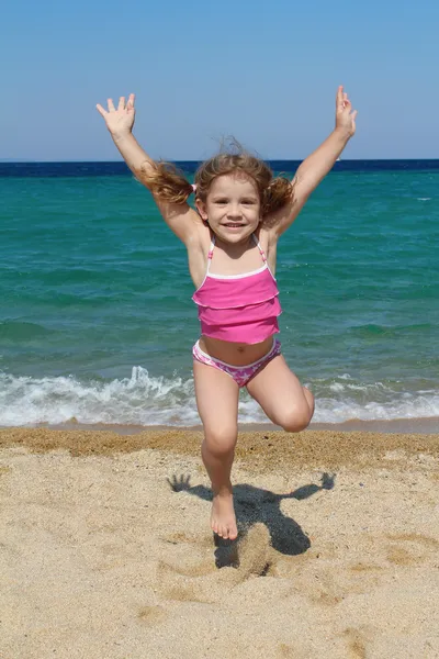 快乐的小女孩，在沙滩上跳跃 — 图库照片