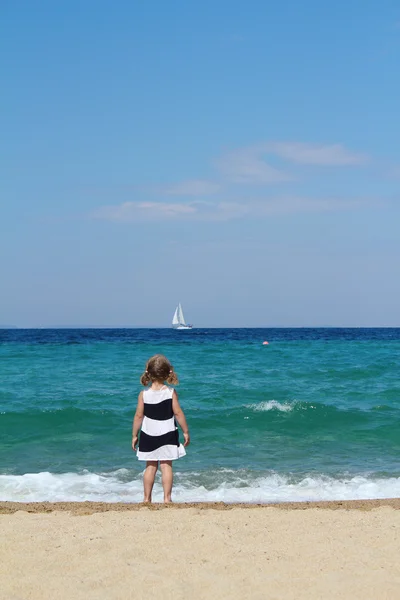 Little girl looking boat at sea — Stock Photo, Image