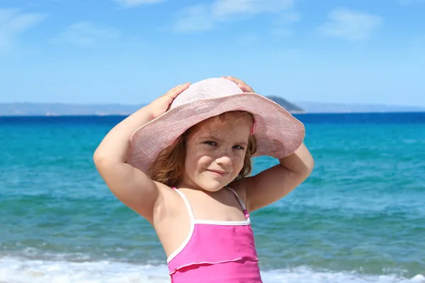 Little girl with straw hat on beach — Stock Photo, Image