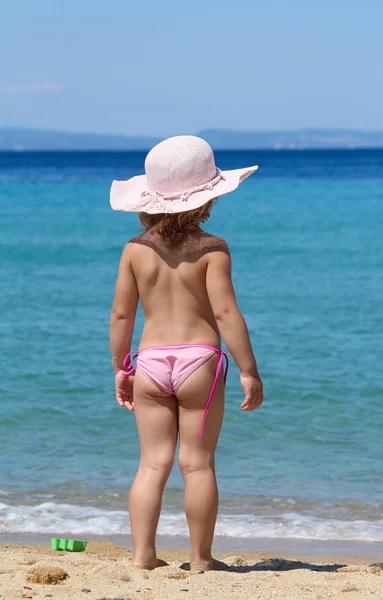 Meisje met stro hoed op zoek op zee — Stockfoto