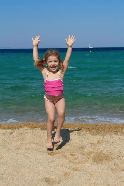 快乐的年轻女孩在海滩上跳跃 — 图库照片