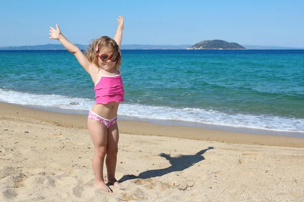 Happy young girl with hands up on the beach — Stock Photo, Image