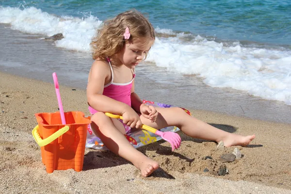 Niña jugando en la playa — Foto de Stock