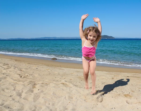 Mutlu küçük kız sahilde atlama — Stok fotoğraf
