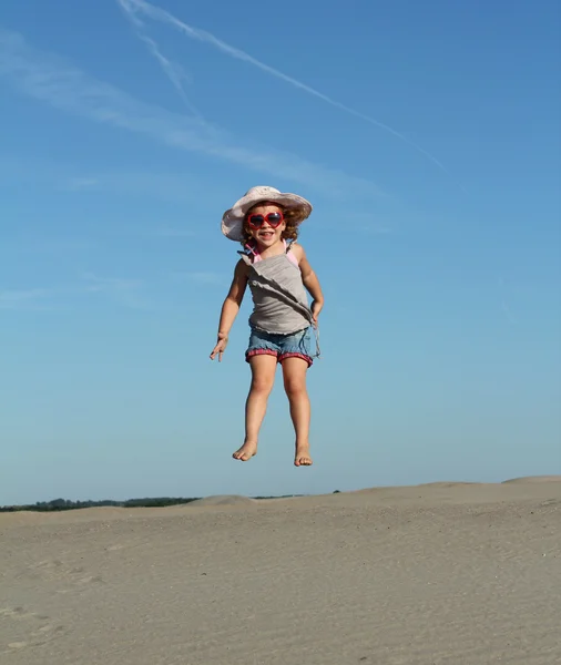 Счастливая маленькая девочка прыгает в высоту — стоковое фото