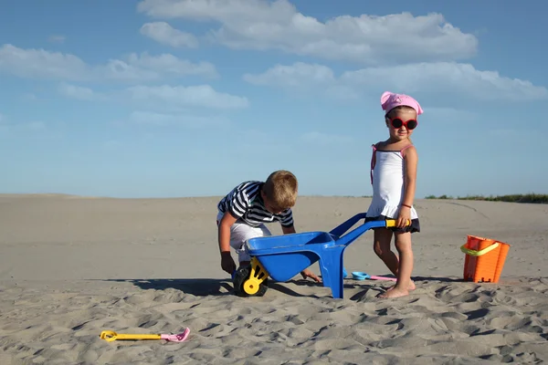 Küçük kız ve kumda oynayan küçük çocuk — Stok fotoğraf