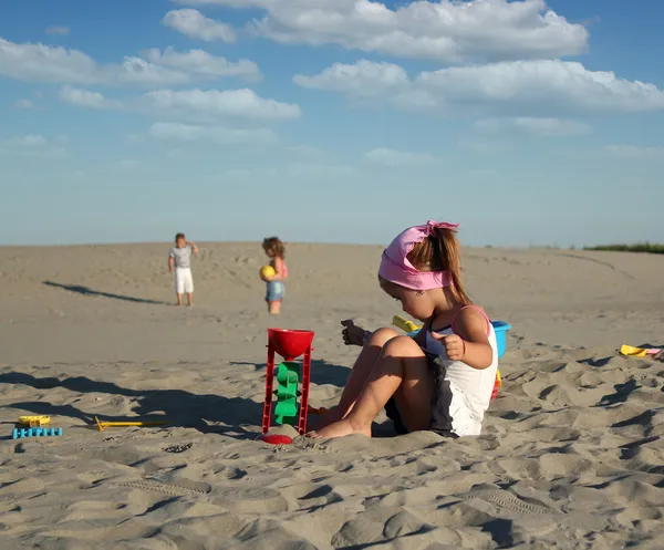 Liten flicka spelar med sand — Stockfoto