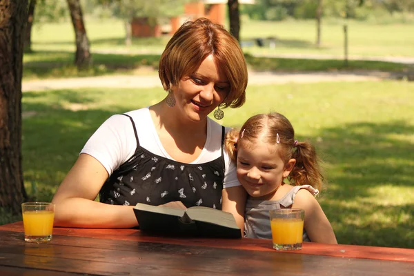 Mutter und Tochter lesen ein Buch — Stockfoto
