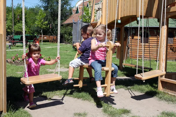 Três crianças no parque infantil — Fotografia de Stock