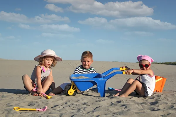 Tre barn leker i sanden — Stockfoto