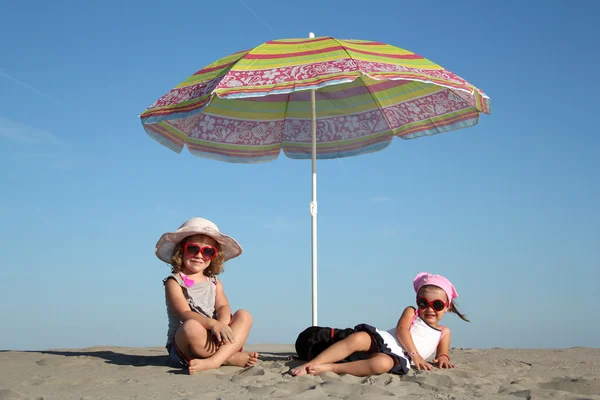 Two little girl under sunshade — Stock Photo, Image