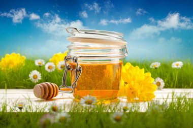 Jar of honey and spring flowers clipart