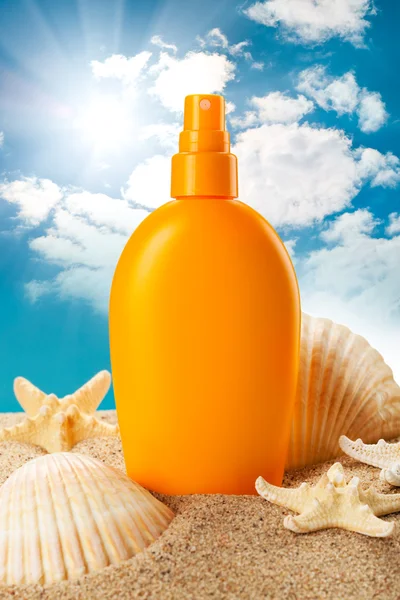 Suntan oil and sea shells — Stock Photo, Image