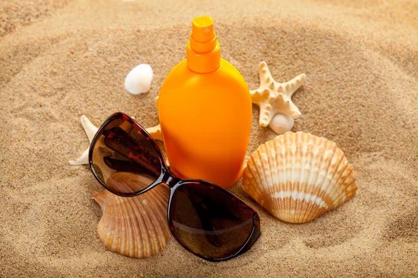 Yaz plaj - güneş yağı ve koyu gözlük kum üzerinde — Stok fotoğraf