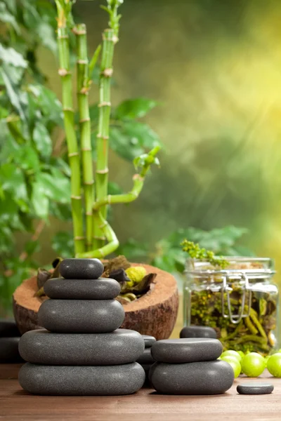 Spa treatment - hot stones on bamboo background — Stock Photo, Image