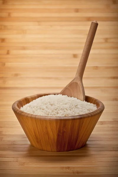 Ryż w misce i drewnianą łyżką — Zdjęcie stockowe