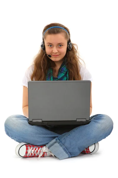 Dizüstü bilgisayarı ve kulaklığı olan genç — Stok fotoğraf