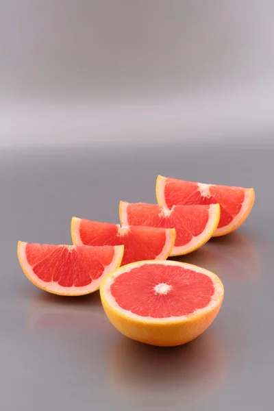 Grapefruit slices on silver background — Stock Photo, Image