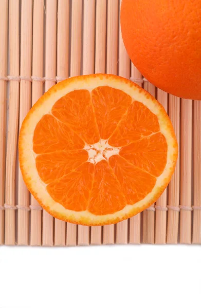 잘 익은 오렌지와 대나무 매트에 오렌지의 절반 스톡 이미지