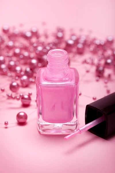 Рожевий лак для нігтів на рожевому фоні — стокове фото