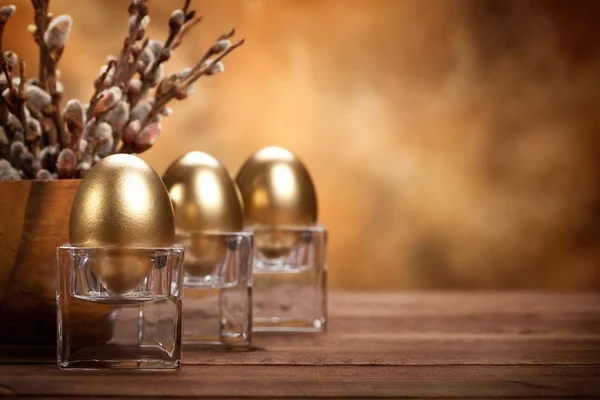 Pasen - gouden eieren op bruine achtergrond — Stockfoto