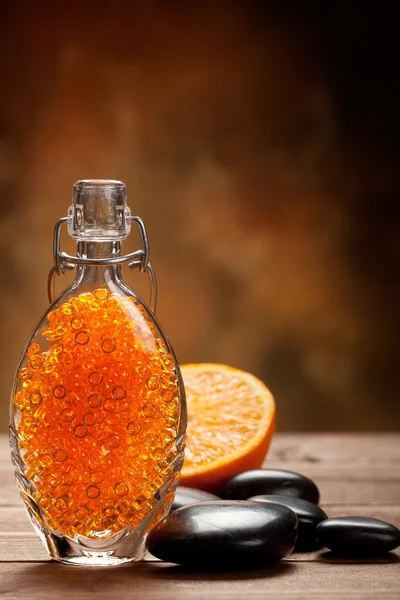 Orangefarbenes Badesalz und Massagesteine — Stockfoto