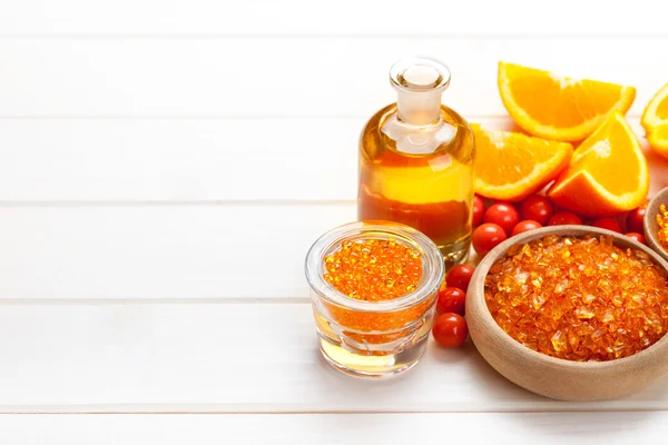 Wellness-Mineralien - orangefarbenes Badesalz und Früchte — Stockfoto