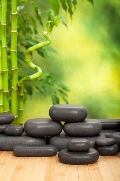 Pietre termali nere su sfondo di bambù verde — Foto Stock