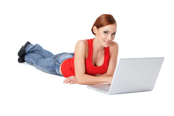 Mujer linda acostada y usando una computadora portátil — Foto de Stock