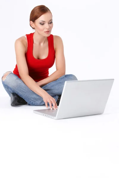 Linda hembra sentada y usando un portátil — Foto de Stock