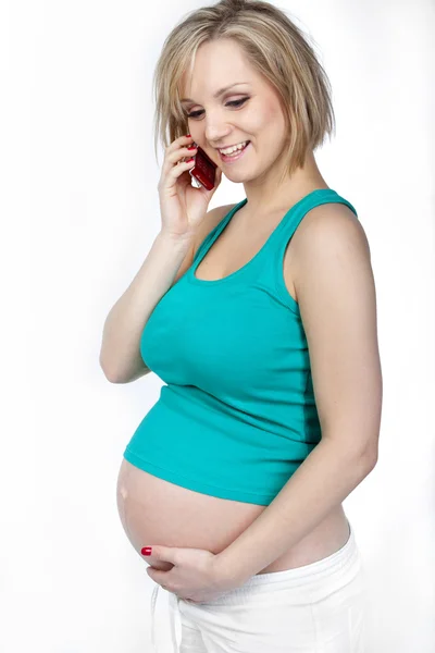 Mujer embarazada hablando por teléfono y sonriendo — Foto de Stock