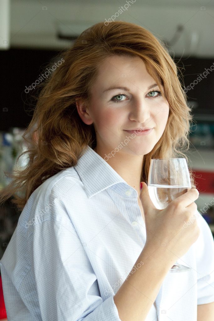 Pretty young women thinking with glass of water near the window — Stock ...