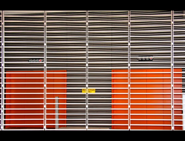 Orangefarbene Räume hinter Metalllatten — Stockfoto