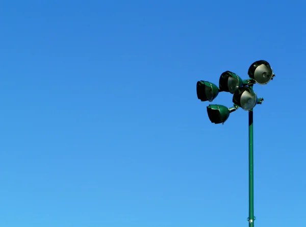 Luce dello stadio sportivo contro il cielo blu — Foto Stock
