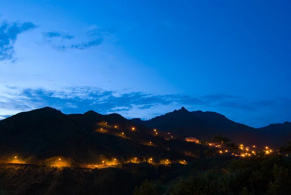 Sicksack vägen med ljus till toppen av berget — Stockfoto