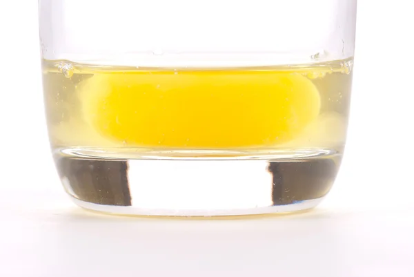 Œuf frais avec jaune sur une tasse en verre — Photo