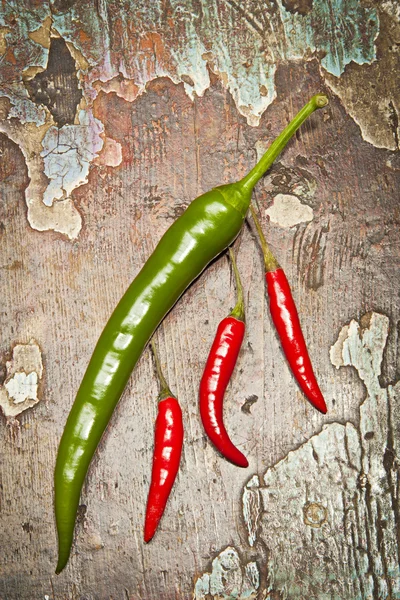 旧背景上的红色和绿色辣椒 — 图库照片