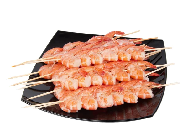 stock image Skewers of shrimp on a black plate
